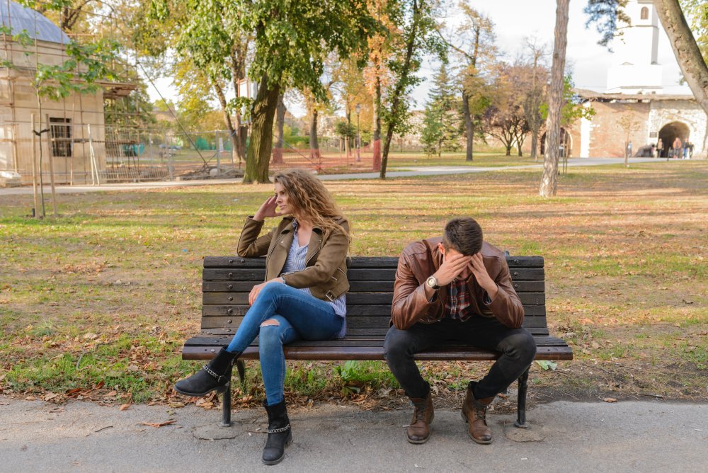 man and woman in stressful situation sitting on bench