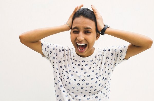 woman squeezing head with hands