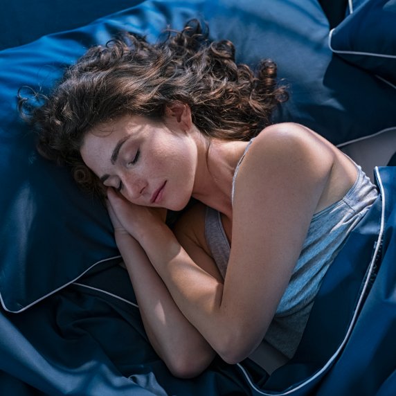 Woman asleep in blue sheets