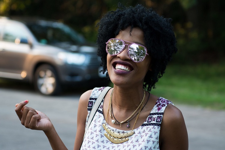 woman outside with sunglasses and a smile