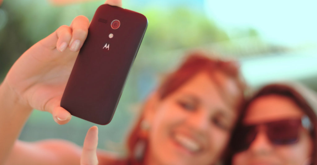 Two women taking a selfie with a Motorola cell phone